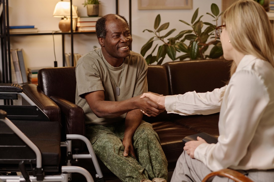 Veteran Support In-Home Care Services | At Your Side - veteran-in-wheelchair-shaking-hands-with-caregiver